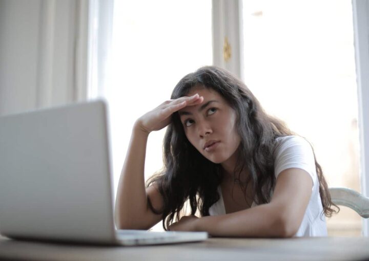 annoyed woman looking away while using laptop