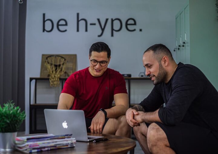 men looking at a website on laptop